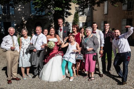 Groupe de famille et amis célébrant un mariage en plein air.