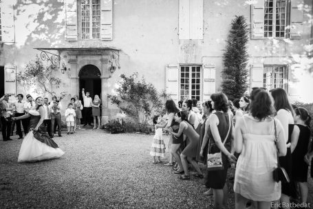 Une mariée danse au centre, entourée d'invités dans un jardin ensoleillé.