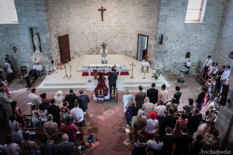 Cérémonie de mariage dans une église avec invités et décorations florales.