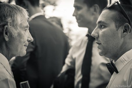 Deux hommes en conversation, l'un en costume, l'autre en tenue décontractée.