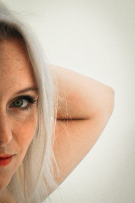Femme aux cheveux blonds, regard intense, mettant en valeur un maquillage subtil.