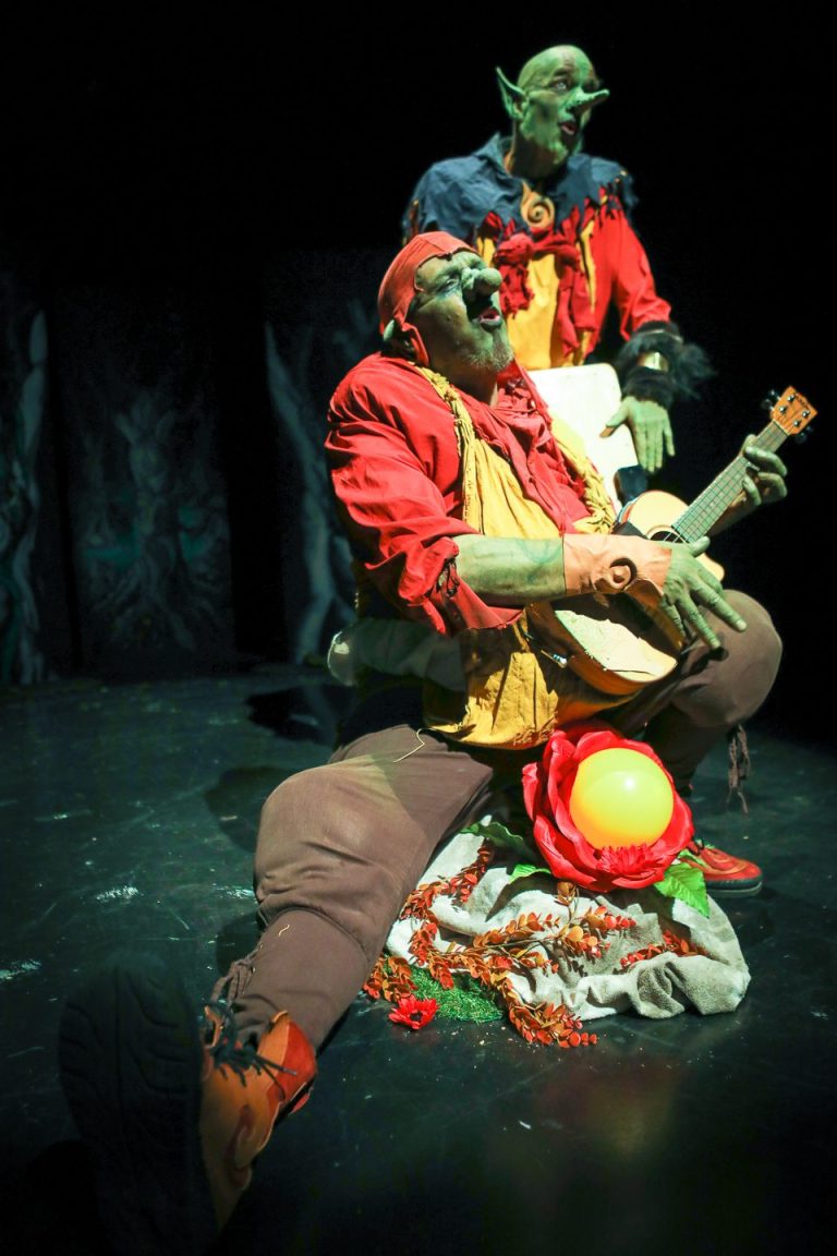 Deux hommes en costume, l'un se penchant vers l'autre dans une pose expressive.