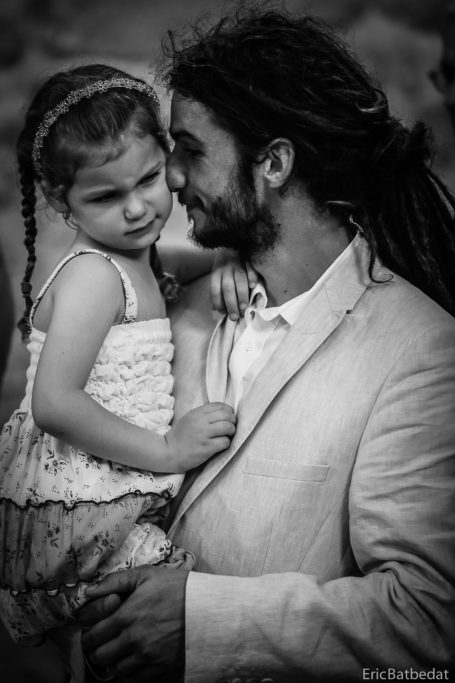 Homme en costume portant une petite fille, moment tendre en noir et blanc.