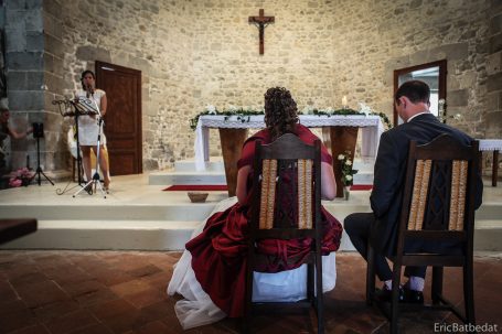 Cérémonie de mariage avec couple assis face à l'autel en pierre.