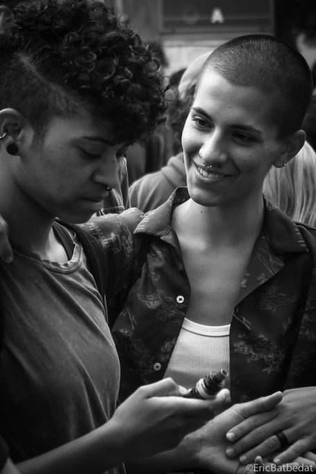 Deux jeunes femmes souriantes, l'une regardant son téléphone, en arrière-plan flou.